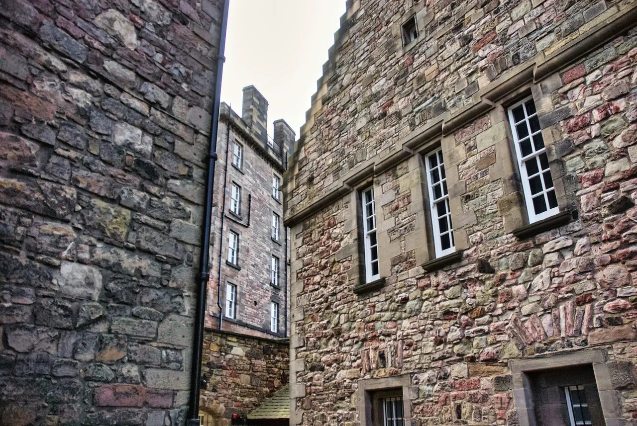 Old stone buildings with windows in a narrow Edinburgh alley